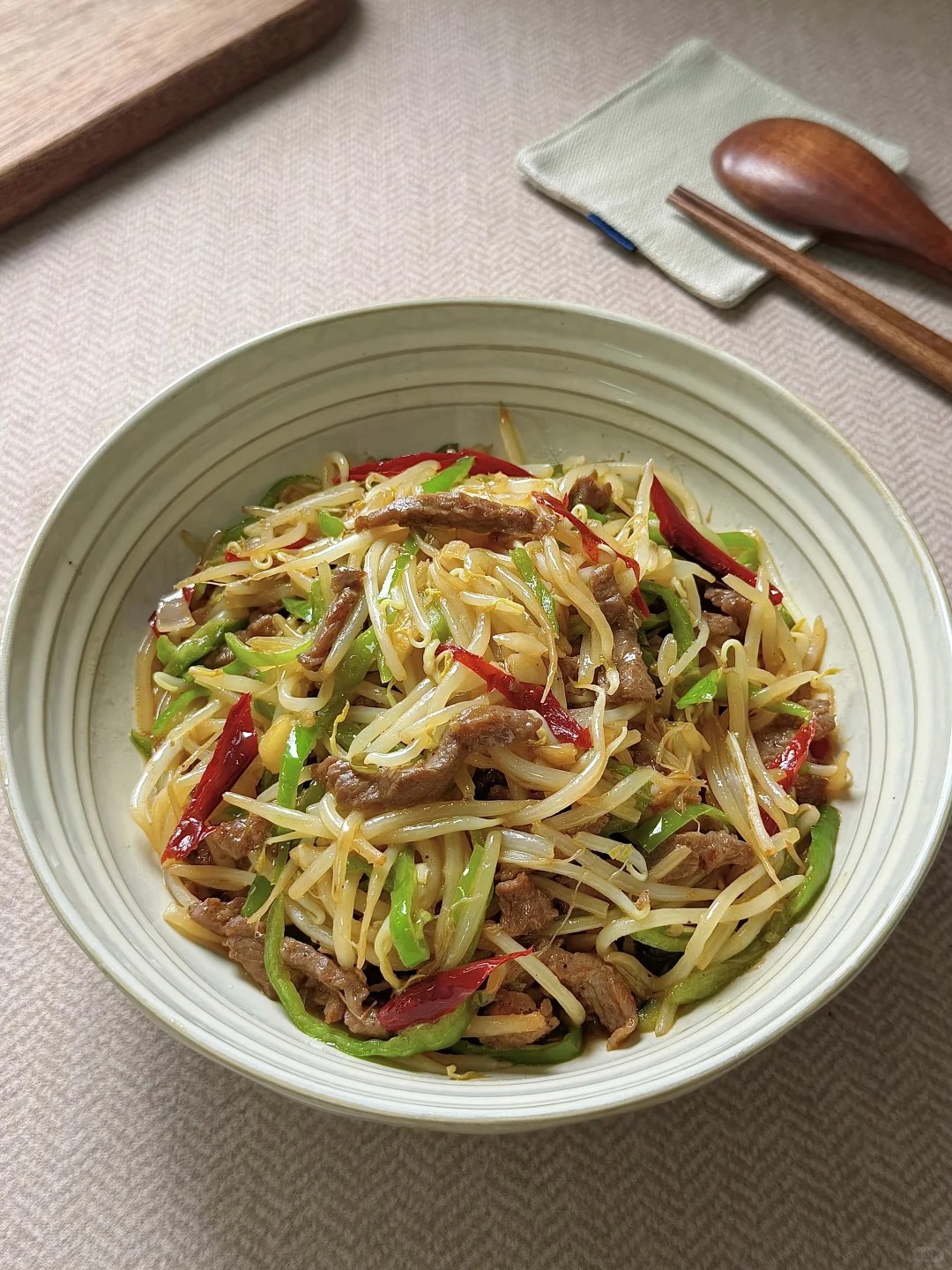 Beef strips and pale bean sprouts with green pepper.