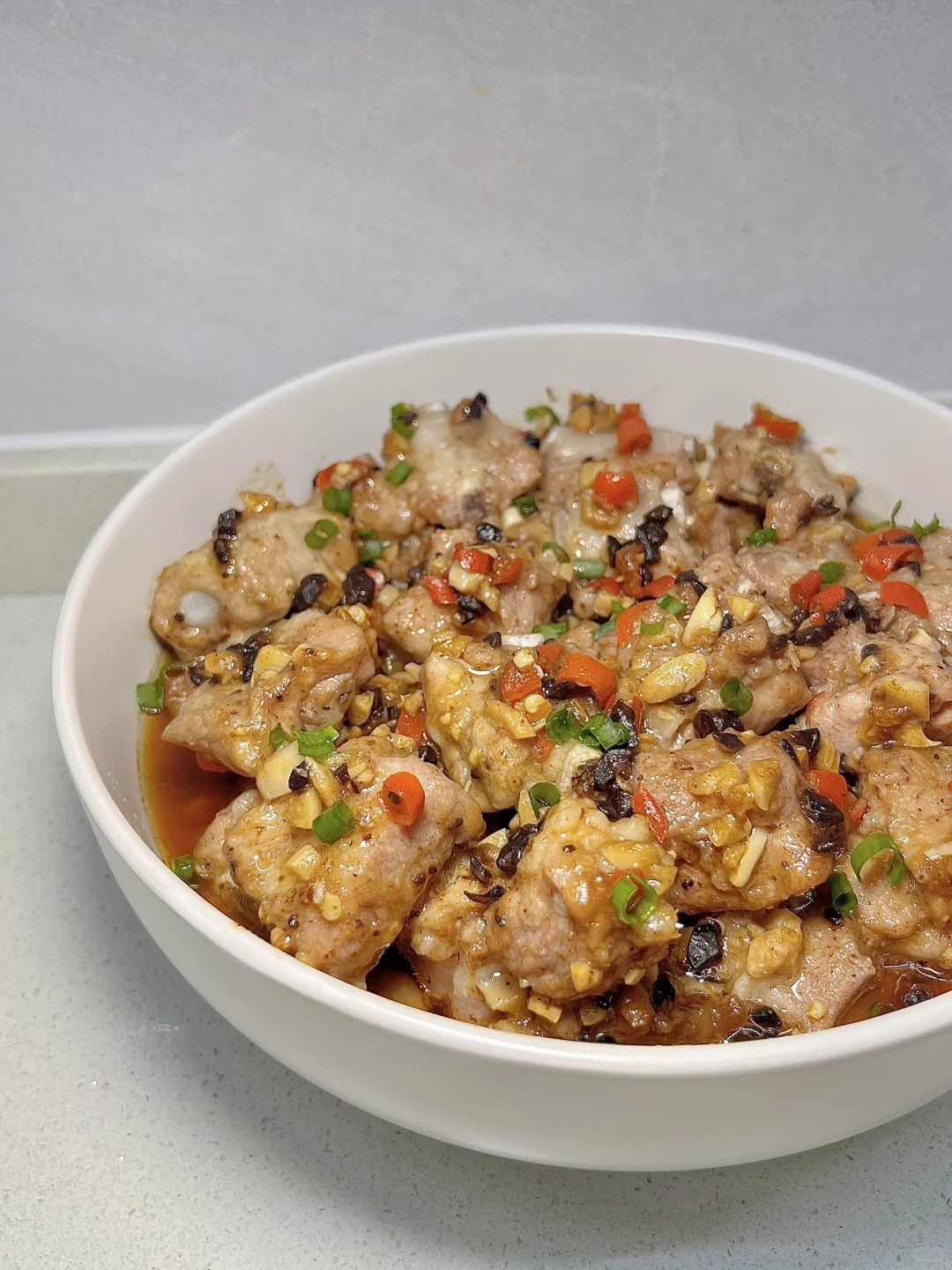 Steamed pork rib pieces with chopped garlic and red chiles.